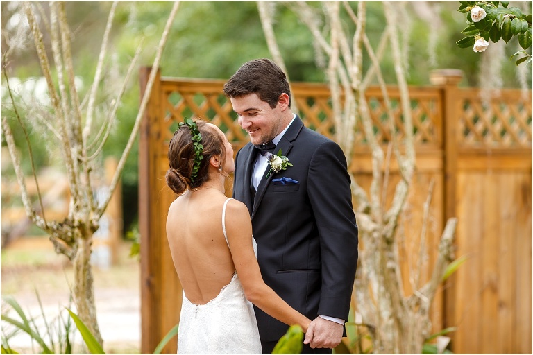 the groom smiles down at his beautiful bride during their first look pros