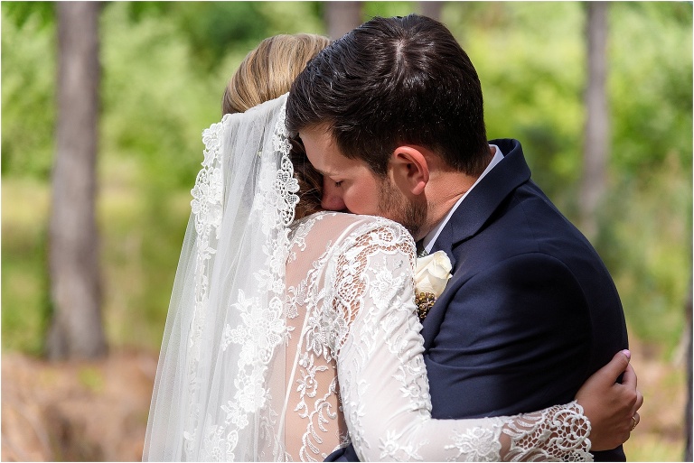 the groom hugs his bride tight during their first look