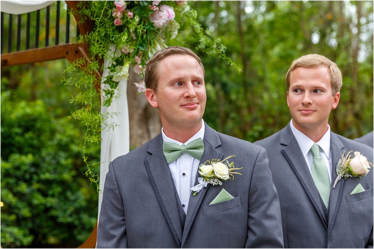 the groom fights back tears as he sees his bride come down the aisle