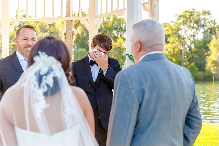 a peek at the crying groom between the bride and her father at their crystal river wedding