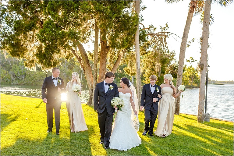 the sun reflects off the river as the wedding party walk arm in arm at their crystal river wedding
