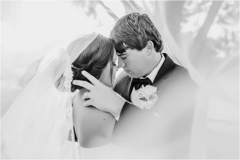 the bride and groom nose to nose under the bride's veil at their Crystal River wedding