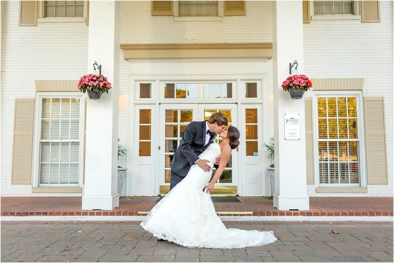 the groom dips his bride outside the pillars of the Plantation on Crystal River 