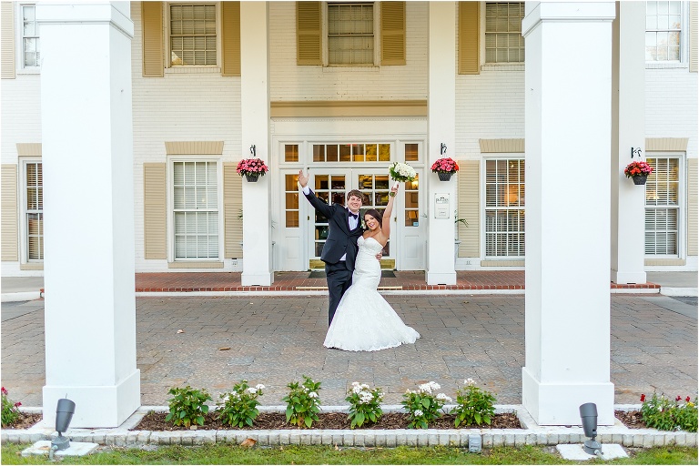 the bride and groom cheer outside the main entrance to Plantation at Crystal River