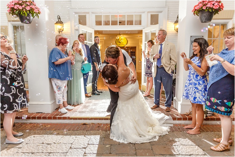 the groom dips his bride during their bubble grand exit at their Crystal River wedding reception