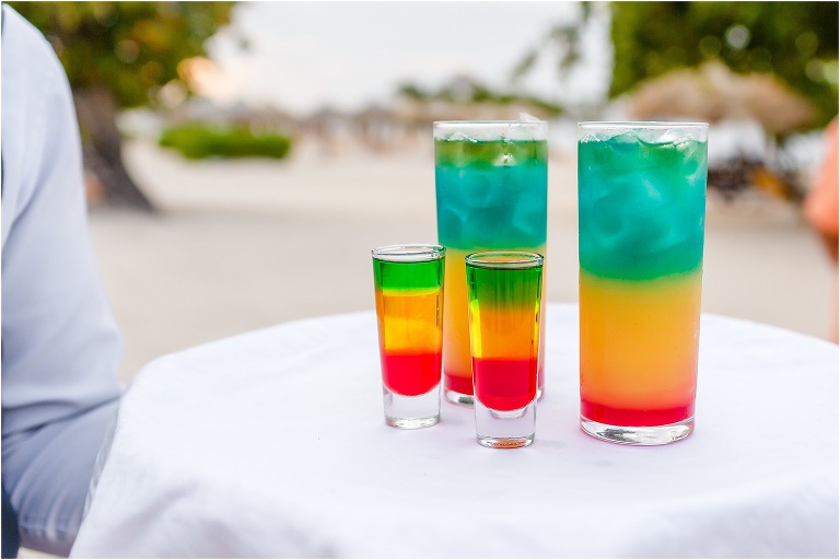 a server presents a tray with brightly colored, layered Bob Marley shots and cocktails