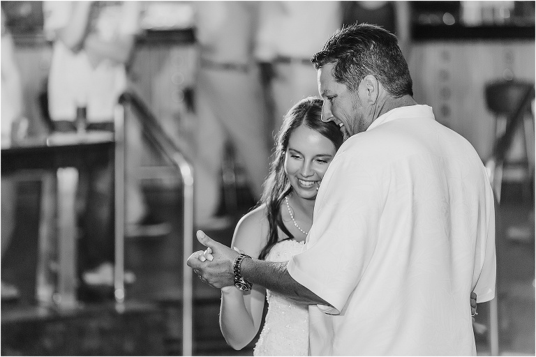 the bride and her father both smile as they share their father daughter dance