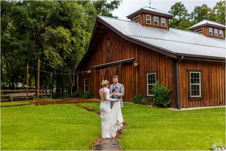 bride & groom share a moment in the rain after their Florida barn wedding