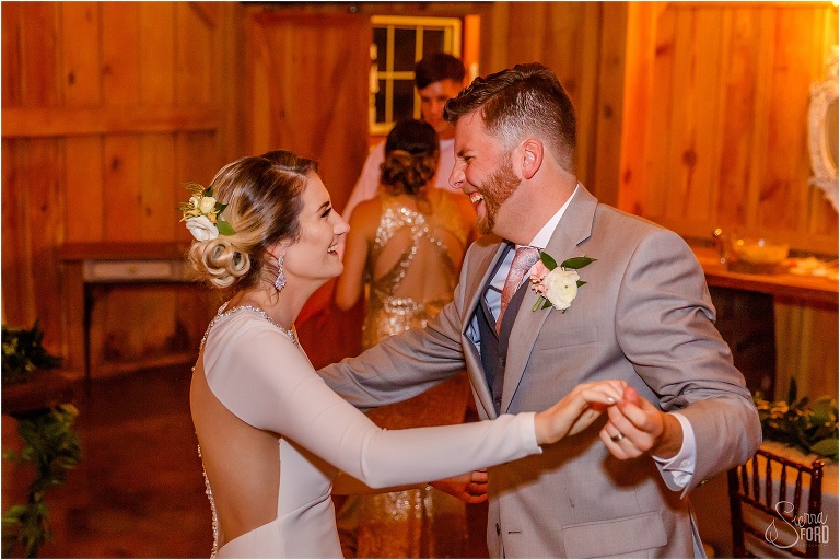 bride & groom laugh as they dance together at their Florida barn wedding