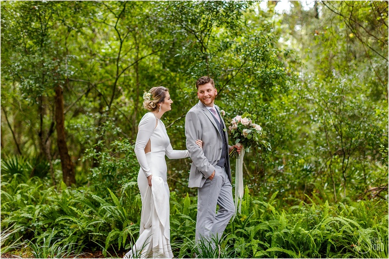 bride & groom walk arm in arm through gardens at Bridle Oaks wedding
