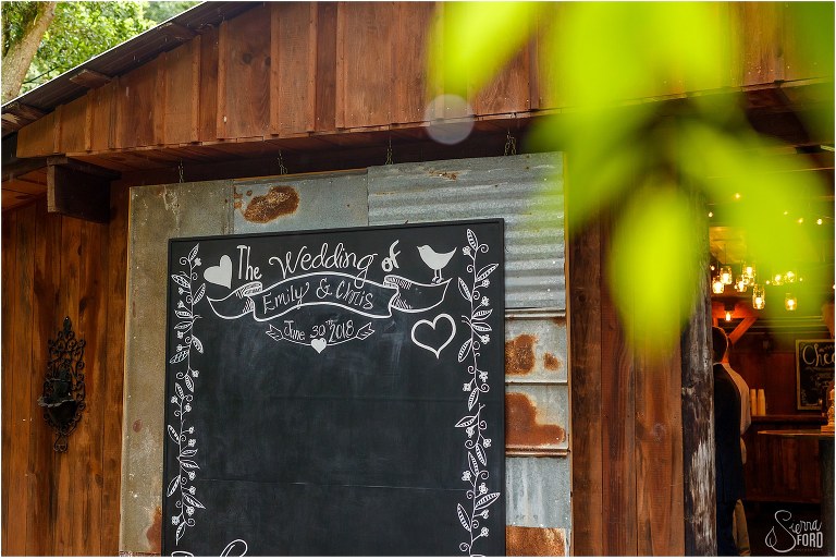 chalkboard design through leaves at Bridle Oaks DeLand barn wedding