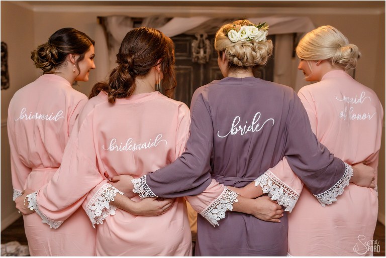 bride & bridesmaids wearing pink and purple personalized robes at DeLand barn wedding