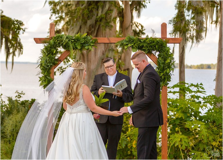 bride & groom exchange vows under custom arch with garland designed by Garland Guy at Mission Inn wedding