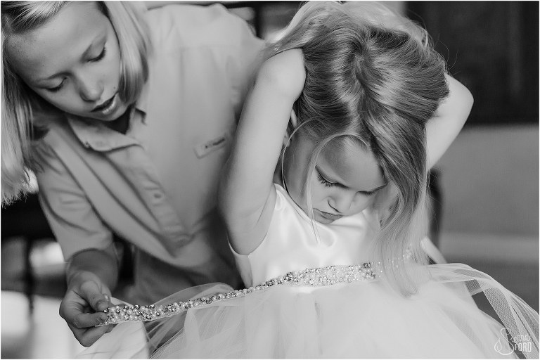 bride's niece helps get bride's daughter into her dress before Mission Inn wedding