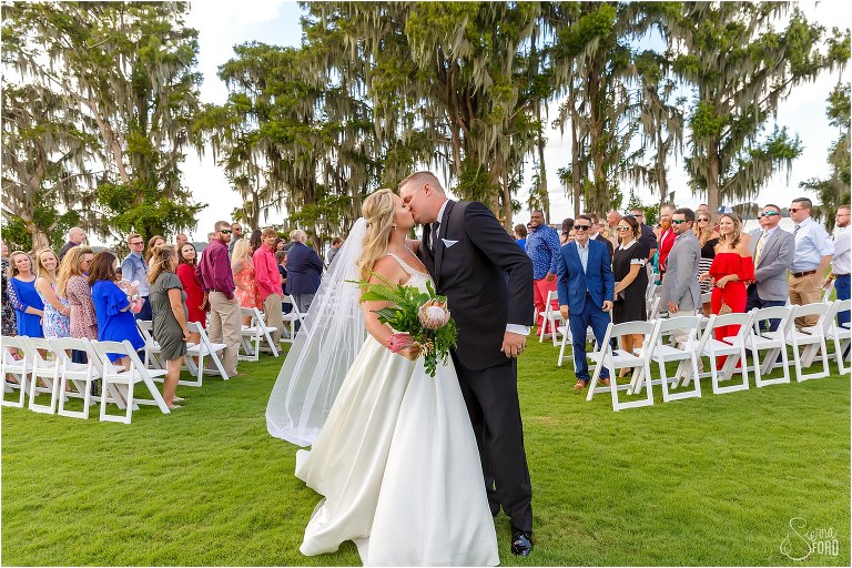 bride & groom share kiss as friends & family cheer after Mission Inn wedding ceremony