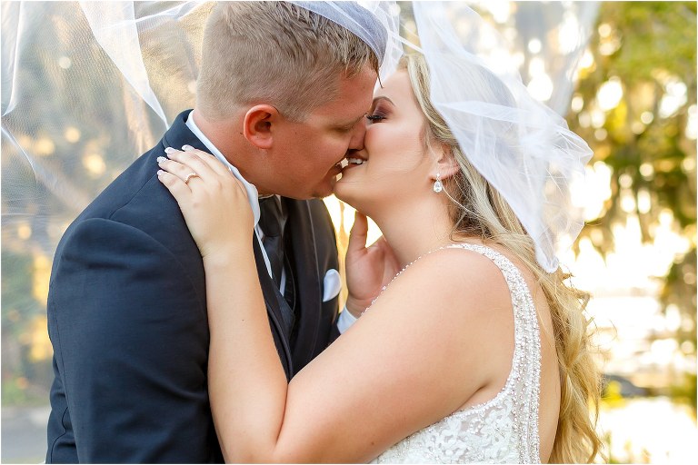 bride & groom share a kiss under veil as the sun peeks through at Mission Inn wedding