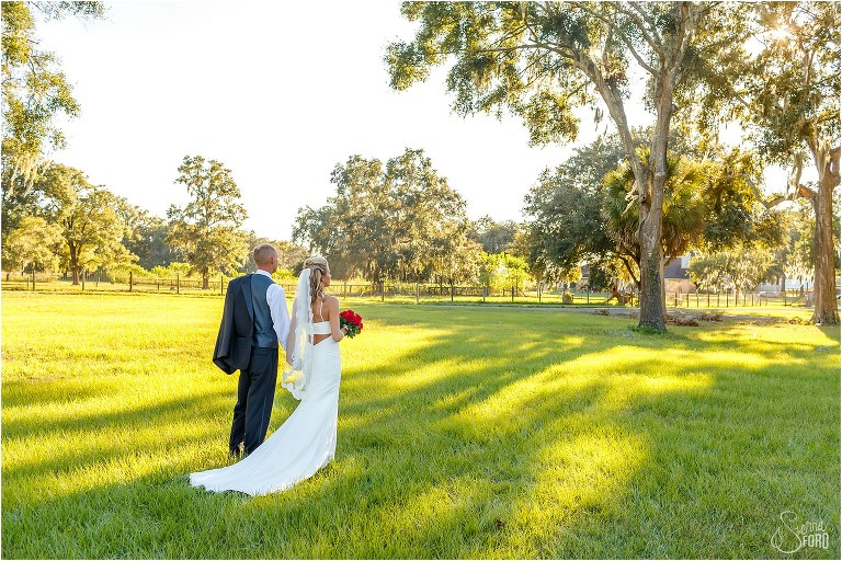bride & groom look off at Whispering Oaks Winery before their Central Florida winery wedding