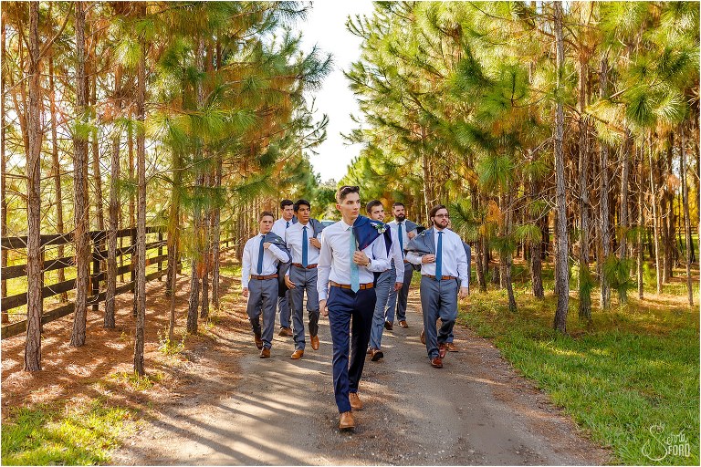 groom & groomsmen walk along tree-lined path at Club Lake Plantation wedding