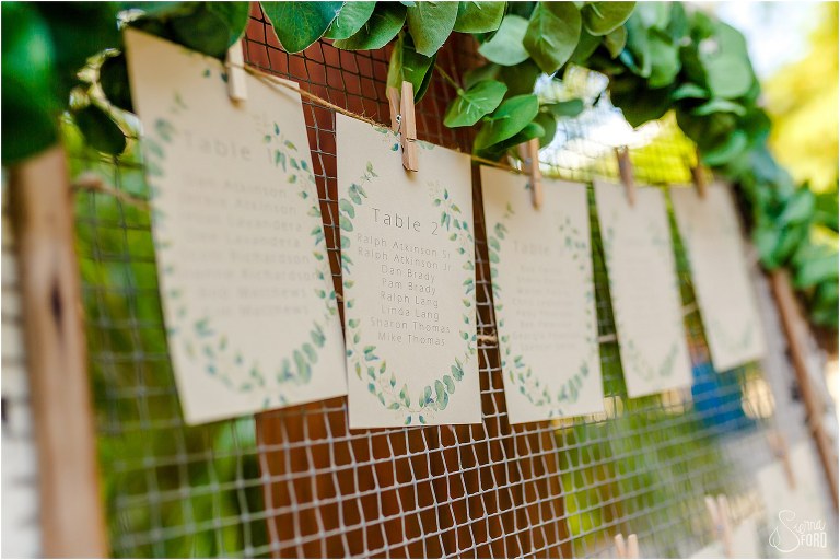 tan and green floral escort cards at Club Lake Plantation wedding