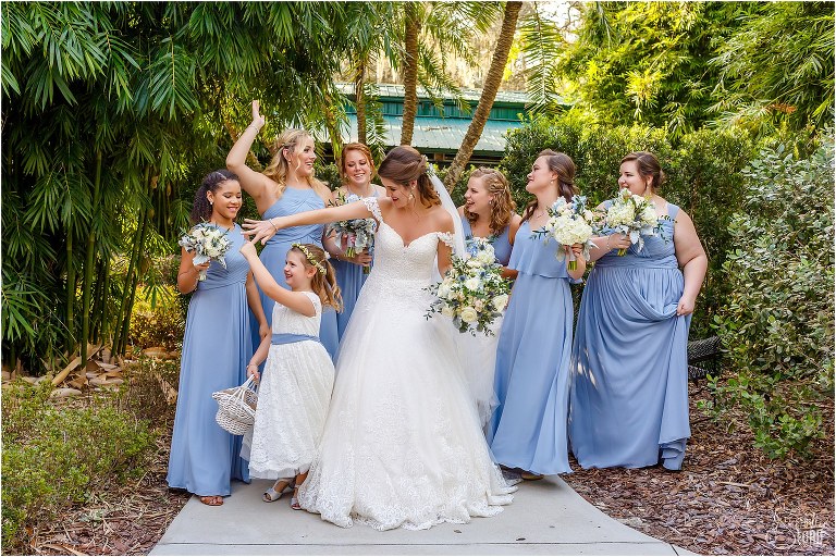 bride twirls flower girl as bridesmaids laugh at Club Lake Plantation wedding
