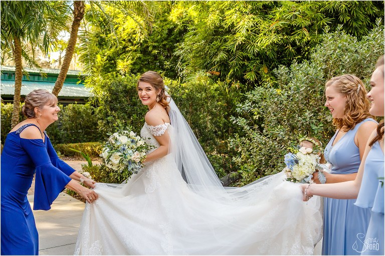 mother of the groom & bridesmaids help get bride's dress situated before Club Lake Plantation wedding