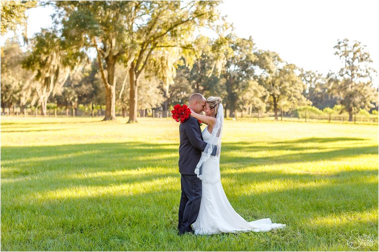 bride & groom forehead to forehead in sunny field at Central Florida winery wedding