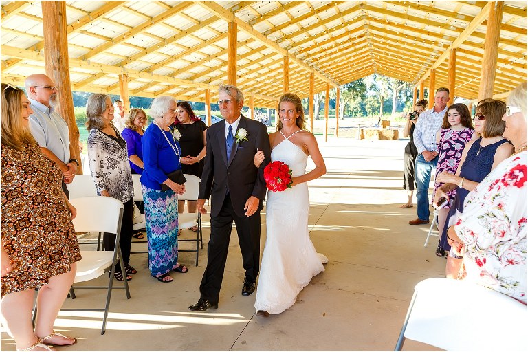 bride & father walk down the aisle as friends & family look on at Central Florida winery wedding ceremony