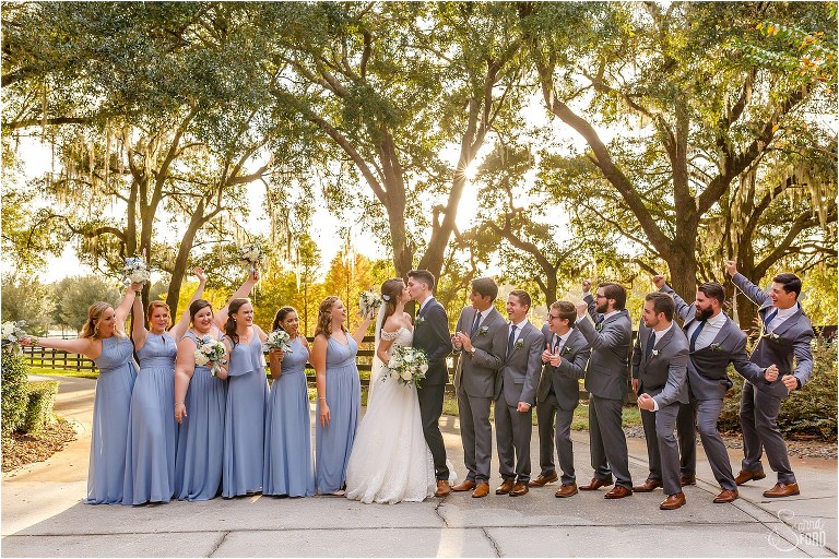 wedding party cheers as bride & groom kiss at Club Lake Plantation wedding