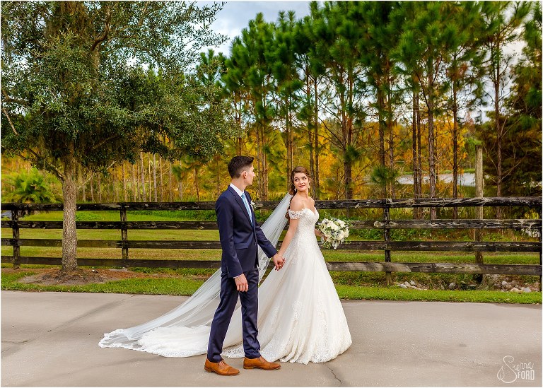 bride leads groom along path after Club Lake Plantation wedding