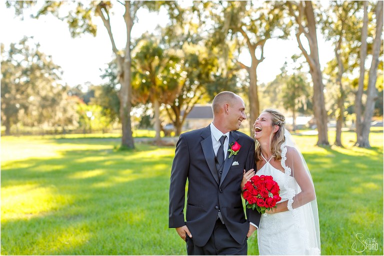 bride laughs hysterically at groom as they walk before Central Florida winery wedding
