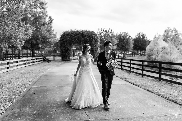 groom carries bridal bouquet as bride walks beside him after Club Lake Plantation wedding
