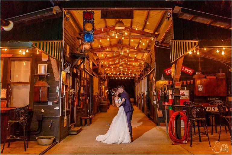 bride & groom kiss under market lights outside at Club Lake Plantation wedding
