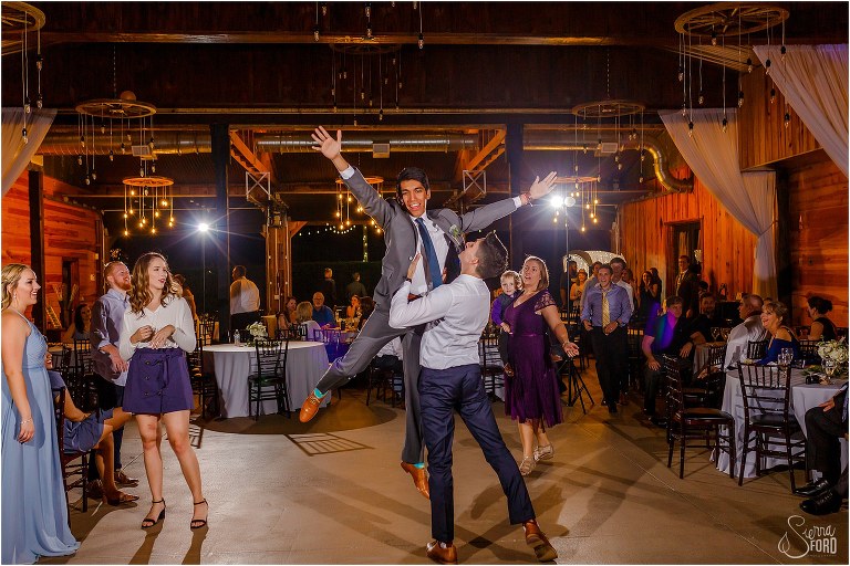 groom lifts his best man on the dance floor at Club Lake Plantation wedding reception