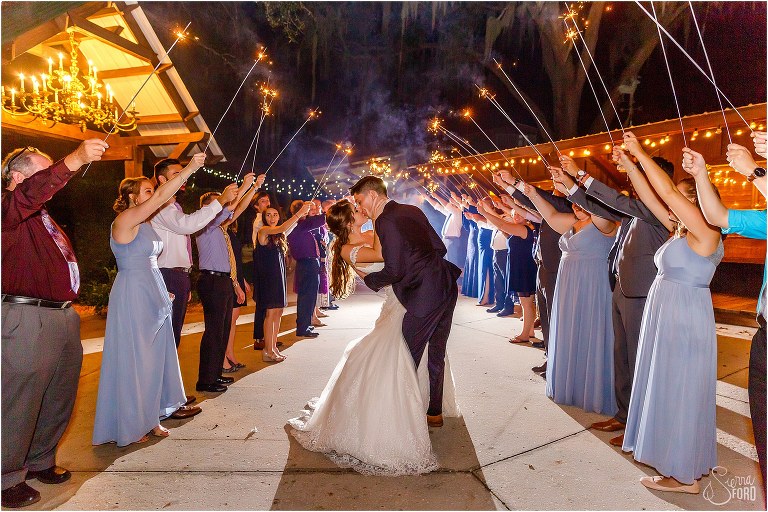 groom dips bride during their sparkler grand exit after Club Lake Plantation wedding reception