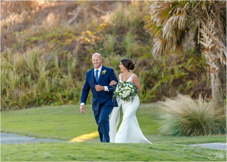 bride & her father laugh together as they walk down the aisle at Amelia Island wedding ceremony