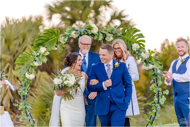 bride & groom grin at each other as they come back down the aisle as husband and wife after Amelia Island wedding ceremony