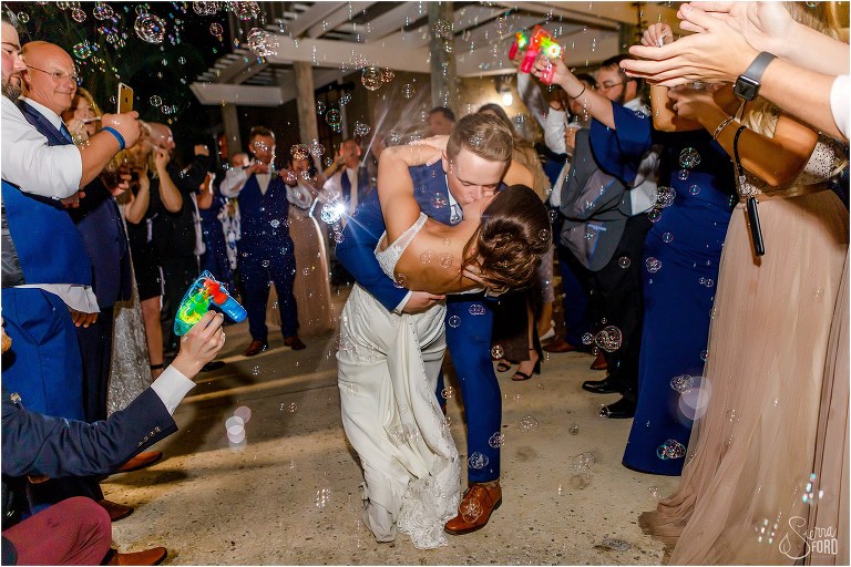 groom dip kisses bride during grand exit surrounded by bubbles at Amelia Island wedding