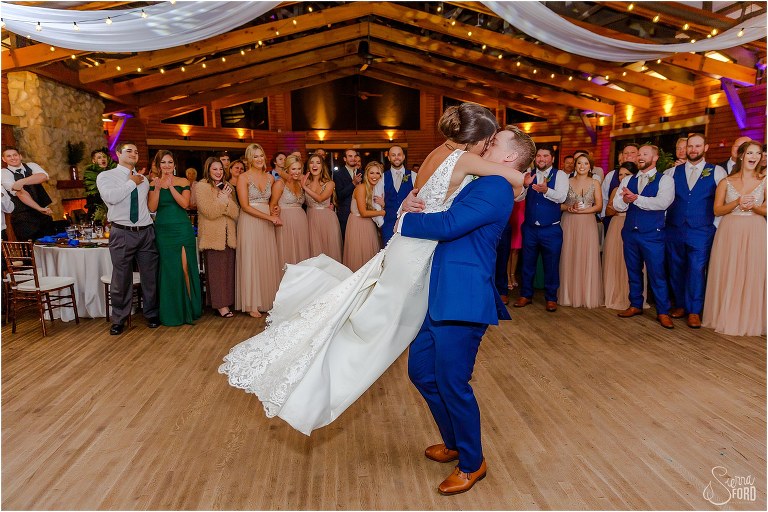 groom lifts bride and kisses her during first dance at Amelia Island wedding reception
