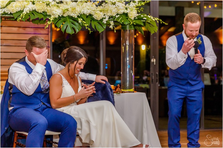 groom hides face with embarrassment as his brother gives best man speech during Amelia Island wedding reception