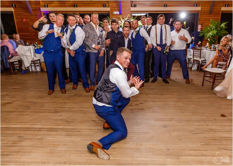 groom poses before throwing garter to men at Amelia Island wedding reception
