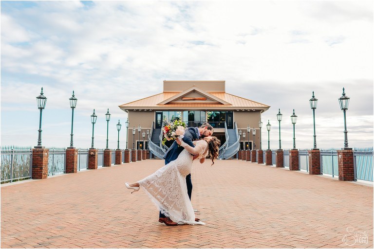 groom dips bride into a kiss on Tavares Pavilion pier during Florida elopement