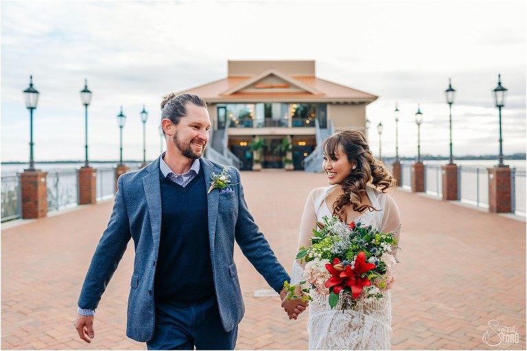 bride & groom laugh as they walk hand in hand down pier at Florida elopement