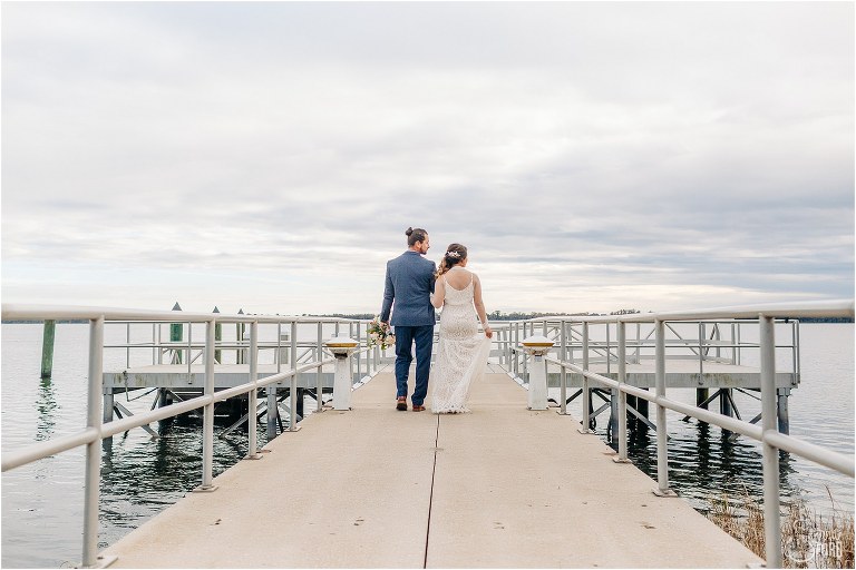 bride & groom walk down the dock at Tavares Pavilion wedding after eloping in florida