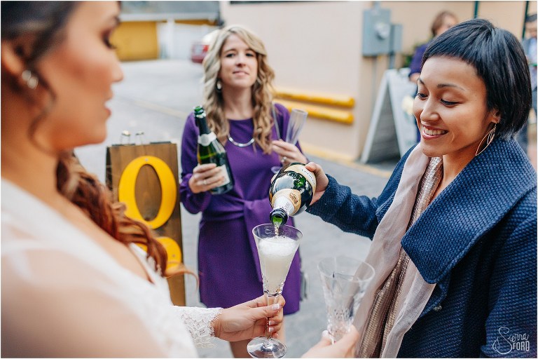 guest pours champagne for bride at Florida elopement reception