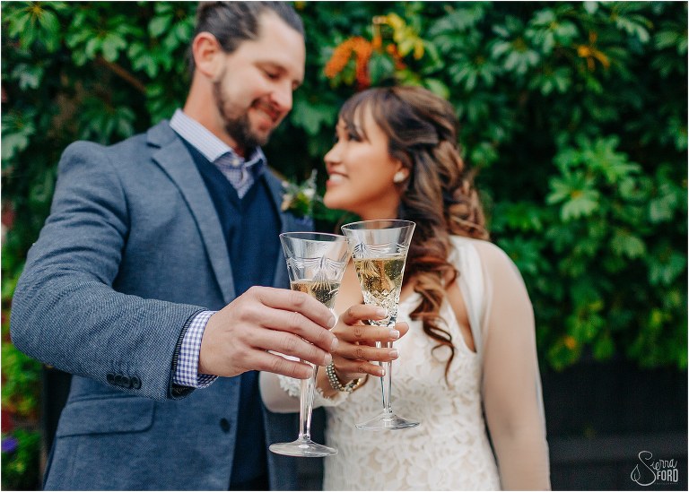 bride & groom look lovingly at each other as they cheers crystal champagne glasses at Florida elopement