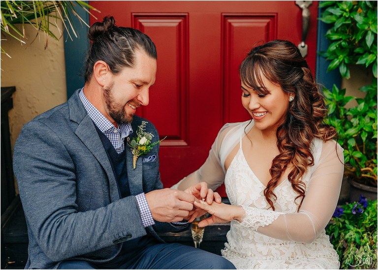 couple smiles while groom plays with bride's wedding ring at Florida elopement