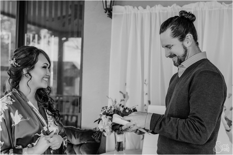 groom smiles as he opens gift from bride before Florida elopement