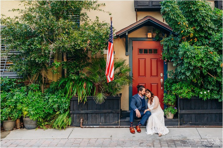 bride & groom snuggle up together on the Goblin Market stoop at Florida elopement