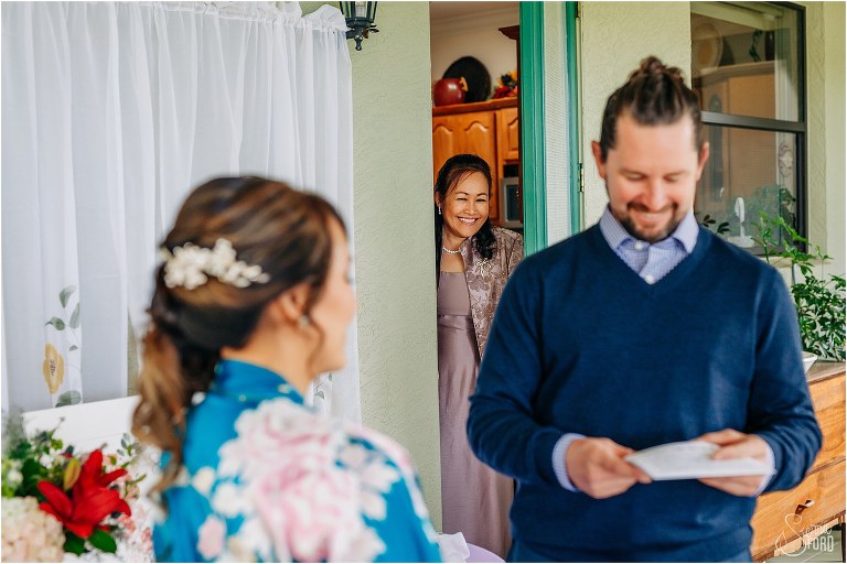 mother of the bride peeks in from house to watch bride & groom exchange gifts before Florida elopement