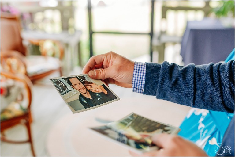 groom goes through photos of bride & groom's relationship before Florida elopement
